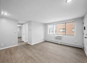 Thumbnail 17 of 35 - the living room and dining room of an apartment with white walls and wood flooring