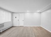 Thumbnail 21 of 35 - the living room of an apartment with white walls and wood floors