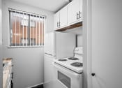 Thumbnail 24 of 35 - a kitchen with a white stove and refrigerator and a window