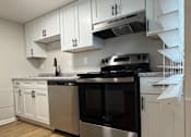 Thumbnail 3 of 18 - A kitchen with stainless steel appliances and white cabinets.