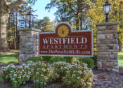 Thumbnail 18 of 31 - a sign for westfield apartments with flowers in front of it