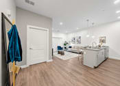 Thumbnail 1 of 58 - A room with a white door, a blue towel hanging on a gold rack, and a grey couch. at The Lumos Apartments, Cleveland, OH