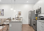 Thumbnail 2 of 58 - A modern kitchen with a granite countertop and stainless steel appliances. at The Lumos Apartments, Cleveland 44106