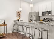 Thumbnail 3 of 58 - A kitchen with a white counter top and stainless steel appliances. at The Lumos Apartments, Ohio, 44106