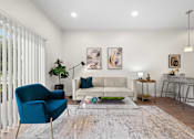 Thumbnail 7 of 58 - A living room with a blue chair and a white couch. at The Lumos Apartments, Cleveland