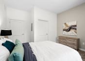 Thumbnail 11 of 58 - A bedroom with a white bed and a painting on the wall. at The Lumos Apartments, Cleveland