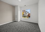 Thumbnail 31 of 58 - A room with a grey carpet and a picture of a house on the wall. at The Lumos Apartments, Cleveland, OH, 44106