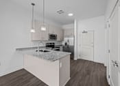 Thumbnail 18 of 58 - A kitchen with a granite countertop and a microwave above it. at The Lumos Apartments, Cleveland, OH