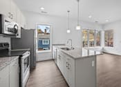 Thumbnail 35 of 58 - A modern kitchen with a large island and stainless steel appliances at The Lumos Apartments, Cleveland 44106