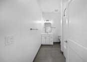 Thumbnail 40 of 58 - A white bathroom with a toilet, sink, and cabinet. at The Lumos Apartments, Cleveland, OH, 44106