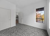 Thumbnail 42 of 58 - A room with a grey carpet and a window showing a balcony. at The Lumos Apartments, Ohio