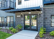 Thumbnail 43 of 44 - The image shows a modern building entrance with a glass door and a number plate above it. at Park Lamont Townhomes Apartments, Cleveland, OH, 44106