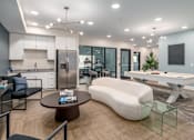 Thumbnail 38 of 44 - A modern kitchen with a breakfast bar and a living room area with a sofa and a coffee table. at Park Lamont Townhomes Apartments, Cleveland