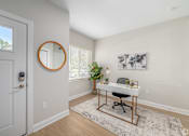 Thumbnail 1 of 44 - A white door with a round mirror on the wall next to a desk with a plant on it. at Park Lamont Townhomes Apartments, Cleveland