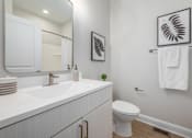 Thumbnail 12 of 44 - A white bathroom with a toilet, sink, and mirror. at Park Lamont Townhomes Apartments, Cleveland, OH, 44106