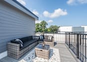 Thumbnail 13 of 44 - A patio with a couch and a table. at Park Lamont Townhomes Apartments, Ohio, 44106