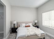 Thumbnail 20 of 44 - A bedroom with a bed, two lamps, and a window with blinds. at Park Lamont Townhomes Apartments, Cleveland, OH
