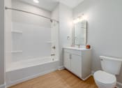 Thumbnail 24 of 44 - A white bathroom with a toilet, sink, and bathtub at Park Lamont Townhomes Apartments, Cleveland, Ohio