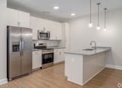 Thumbnail 25 of 44 - A modern kitchen with stainless steel appliances and wooden flooring. at Park Lamont Townhomes Apartments, Cleveland