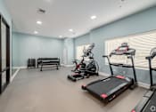 Thumbnail 37 of 44 - A spacious home gym with a treadmill, elliptical machines, and a bench. at Park Lamont Townhomes Apartments, Cleveland