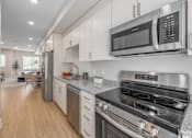 Thumbnail 3 of 44 - A modern kitchen with a stainless steel oven and microwave. at Park Lamont Townhomes Apartments, Cleveland, OH