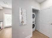 Thumbnail 6 of 44 - A white door is open to a laundry room with a washer and dryer. at Park Lamont Townhomes Apartments, Cleveland, OH