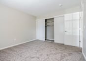 Thumbnail 8 of 18 - A room with a white door and a carpeted floor.