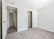Thumbnail 5 of 18 - A room with a carpeted floor and two open doors.