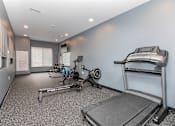 Thumbnail 47 of 58 - A home gym with a treadmill, rowing machine, and weights. at The Lumos Apartments, Cleveland