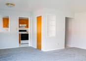 Thumbnail 4 of 20 - an empty living room with a white carpet and a kitchen