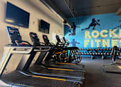 Thumbnail 16 of 19 - A gym with treadmills and a sign that says Rock Fitness. at Vivo Toledo Apartments, Toledo, OH