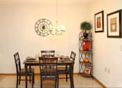 Thumbnail 3 of 15 - A dining room with a table set for two and a clock on the wall.