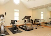 Thumbnail 15 of 15 - A home gym with a rowing machine, a treadmill, and a stationary bike.