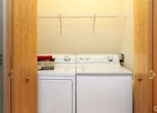 Thumbnail 6 of 15 - A small laundry room with a washer and dryer.