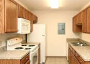 Thumbnail 7 of 15 - A kitchen with wooden cabinets and a white refrigerator.