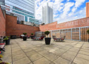 Thumbnail 35 of 35 - a terrace with tables and chairs and a building in the background at Market Square Place, Pennsylvania