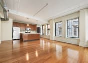 Thumbnail 20 of 35 - an empty living room with a kitchen and a large window at Market Square Place, Pennsylvania