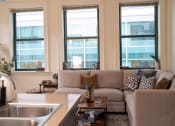 Thumbnail 5 of 35 - a living room with a couch and a kitchen with windows at Market Square Place, Pennsylvania