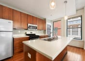 Thumbnail 18 of 35 - a kitchen with wooden cabinets and a white counter top at Market Square Place, Pennsylvania
