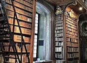 Thumbnail 1 of 3 - a library with two large bookshelves and a large window