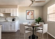 Thumbnail 11 of 33 - Renovated kitchen with white cabinetry, laminate countertop, and wood-style plank flooring  at Acacia Gardens, Albuquerque, New Mexico