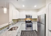 Thumbnail 2 of 26 - a kitchen with stainless steel appliances and white cabinets at Highlands at Faxon Woods, Quincy, 02169