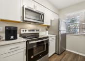 Thumbnail 1 of 33 - a kitchen with stainless steel appliances and white cabinets at Acacia Gardens, Albuquerque, NM, 87111