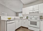 Thumbnail 4 of 30 - a white kitchen with white appliances and white cabinets at Cypress Shores, Coconut Creek, FL