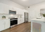 Thumbnail 8 of 36 - a modern kitchen with white cabinets and stainless steel appliances at Paramount on Lake Eola, Orlando, FL