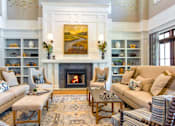 Thumbnail 21 of 33 - A living room with a fireplace and a painting above it.