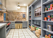 Thumbnail 15 of 33 - A kitchen with a brick wall and a tile floor.