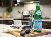 Thumbnail 25 of 52 - a wooden cutting board with two bottles of sparkling water and a frying pan on it  at 511 Meeting, Charleston