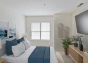 Thumbnail 12 of 26 - a bedroom with a large bed and a tv at Highlands at Faxon Woods, Quincy