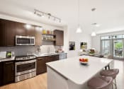 Thumbnail 1 of 22 - a kitchen with a large island and a white counter top at Glenwood at Grant Park Apartments, Atlanta